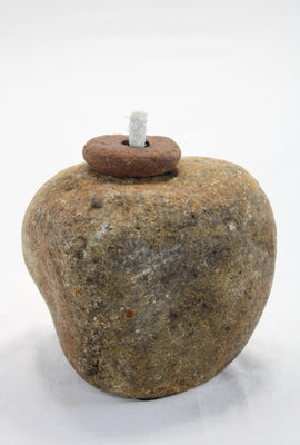 Yellow-brown granite stone tiki lamp with smooth texture and small top stone holding a half inch diameter wick.