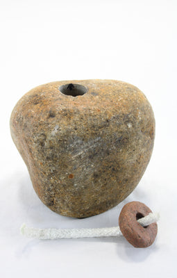 Yellow-brown granite stone tiki lamp with smooth texture . Top stone which holds the wick has be removed to show the drill hole into the main stone which will hold the lamp oil.