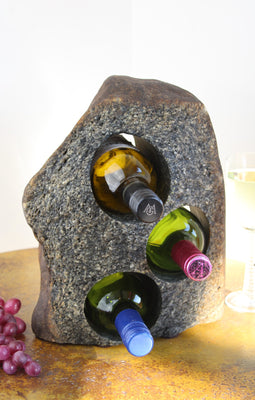 Grey-Brown Granite Stone Wine Rack holding 3 bottles of wine horizontally,  set atop a small table with red grapes and a glass of white wine.