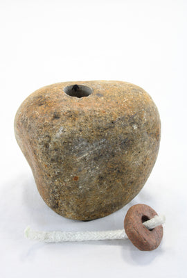 Yellow-brown granite stone tiki lamp with smooth texture . Top stone which holds the wick has be removed to show the drill hole into the main stone which will hold the lamp oil.
