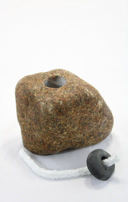 Brown granite stone tiki lamp with smooth texture and  small round dark grey top stone removed, holding the wick and showing the  vertical hole drilled into the stone to hold the lamp oil.
