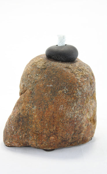 Brown-orange smooth textured granite tiki lamp with small round dark grey stone at the top holding the wick.  Wick is protruding vertically from the top stone about 1 inch.